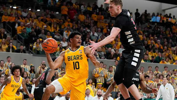 Jan 13, 2024; Waco, Texas, USA; Baylor Bears guard RayJ Dennis (10) passes the ball past Cincinnati Bearcats forward Viktor Lakhin (30) during the second half at Paul and Alejandra Foster Pavilion. Mandatory Credit: Raymond Carlin III-USA TODAY Sports